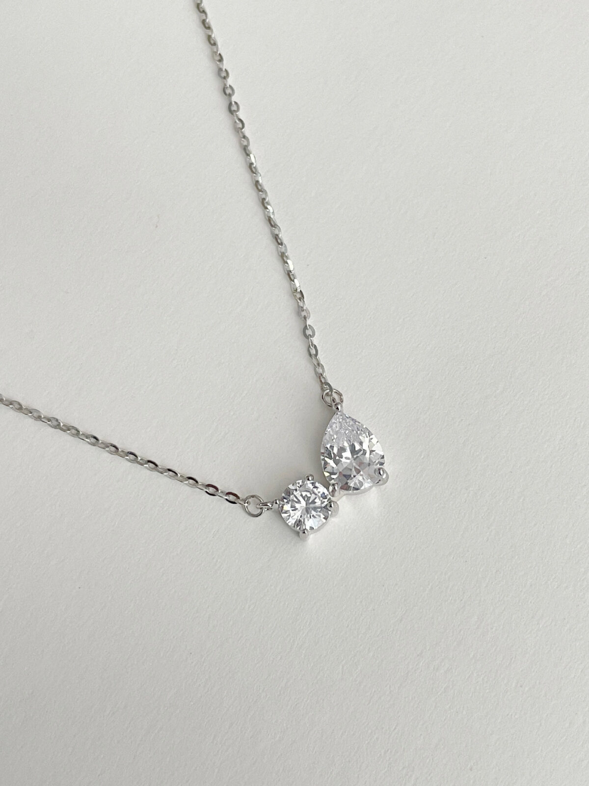 Cadena con dije de gota y círculo y baño de oro blanco