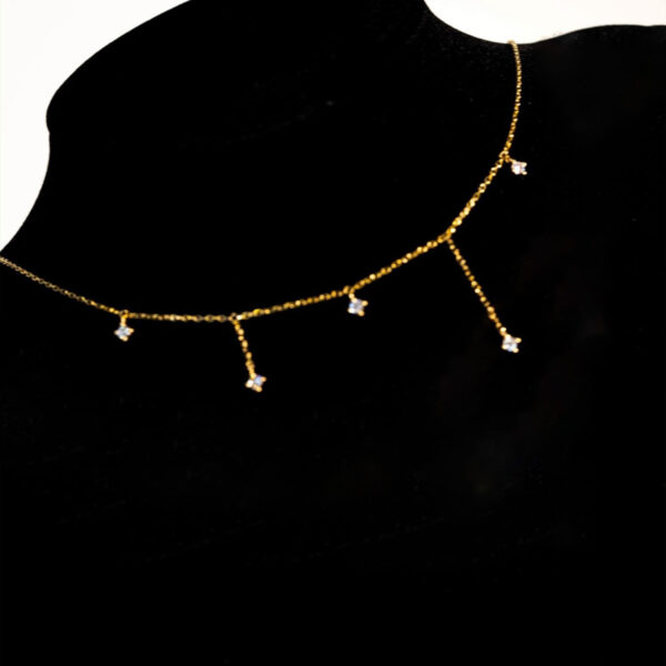 Cadena con dijes de circonitas en caída y baño de oro de 18K
