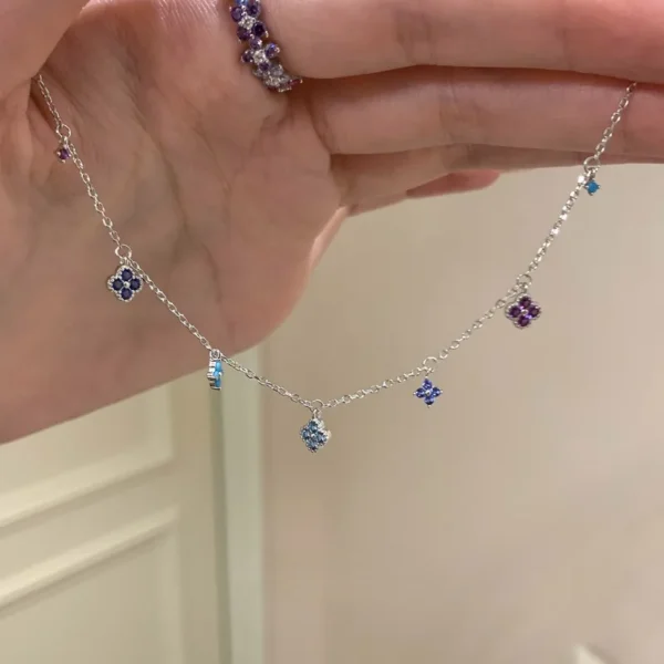 Cadena con dijes varios de flores y circonitas de colores