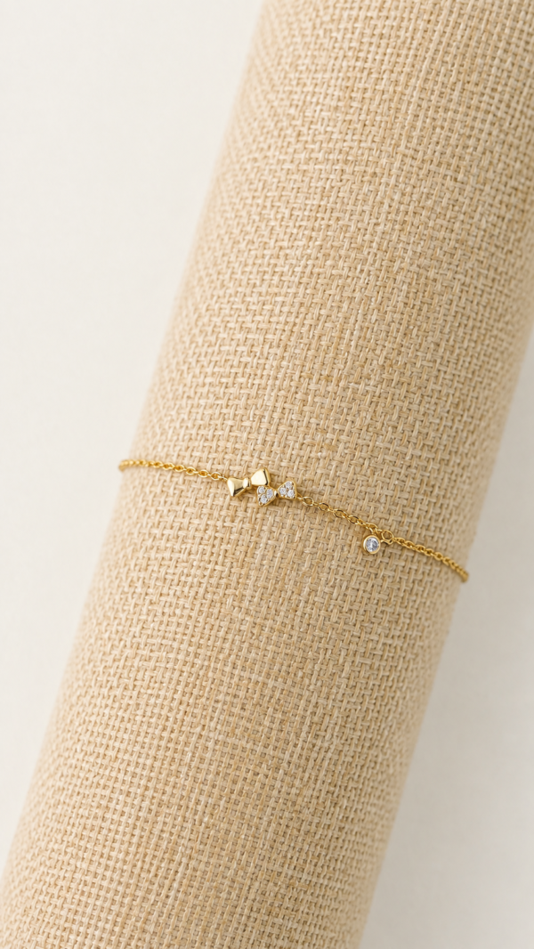 Pulsera con dije de lazo y baño de oro de 18K