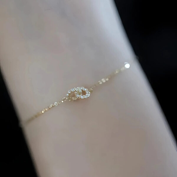 Pulsera con dije de circulos amarrados y baño de oro de 18K
